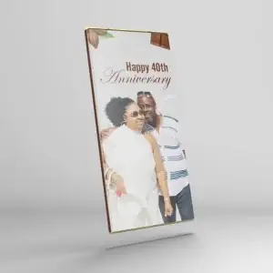 A rectangular chocolate bar packaged with a print featuring a couple smiling and embracing, with the text "Happy 40th Anniversary" written above them in elegant script.